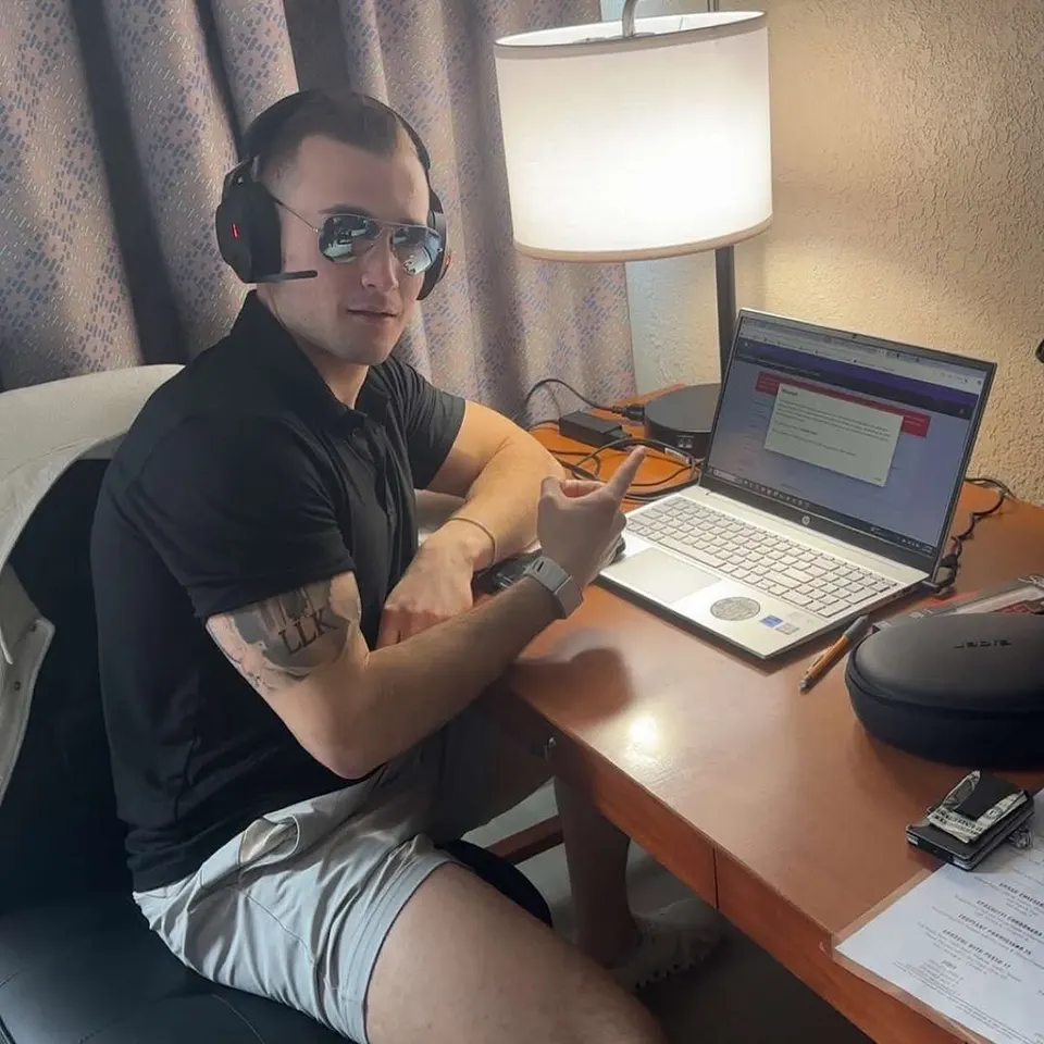 Headset on, laptop open, working from a hotel desk