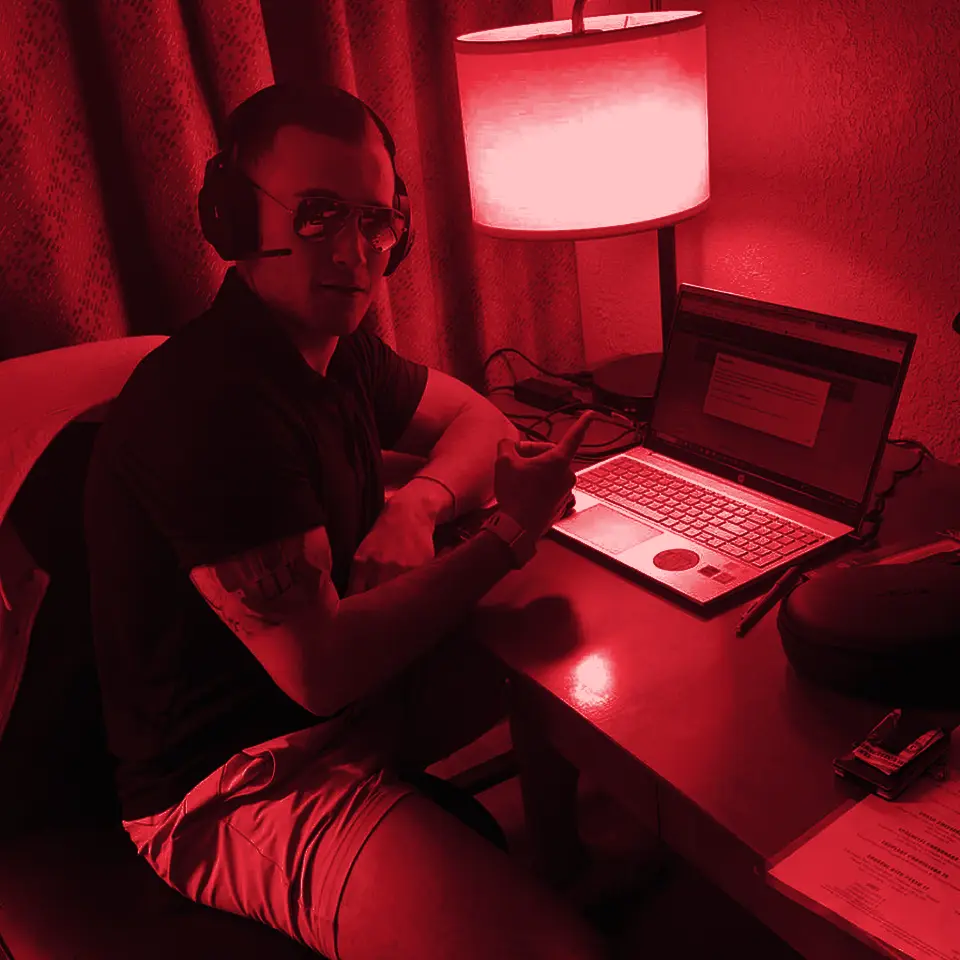 Headset on, laptop open at a hotel desk