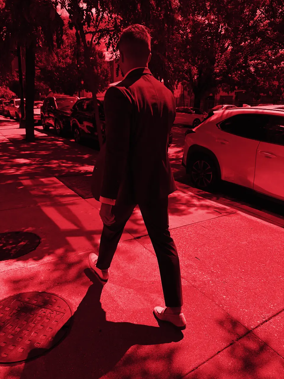 Caiden Sloan in a burgundy suit walking a Chicago street